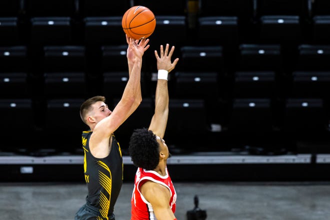 Iowa's Joe Wieskamp, left, shoots a 3-point basket as Ohio State forward Justice Sueing defends defends during a NCAA Big Ten Conference men's basketball game, Thursday, Feb. 4, 2021, at Carver-Hawkeye Arena in Iowa City, Iowa.