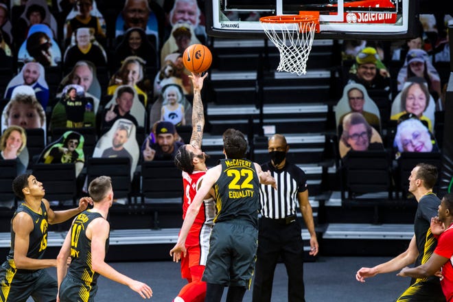 Ohio State guard Duane Washington Jr. (4) makes a basket as Iowa forward Patrick McCaffery (22) defends during a NCAA Big Ten Conference men's basketball game, Thursday, Feb. 4, 2021, at Carver-Hawkeye Arena in Iowa City, Iowa.