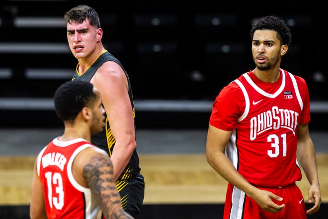 Iowa center Luka Garza, left reacts after drawing a foul in the first half as Ohio State forward Seth Towns (31) looks on during a NCAA Big Ten Conference men's basketball game, Thursday, Feb. 4, 2021, at Carver-Hawkeye Arena in Iowa City, Iowa.