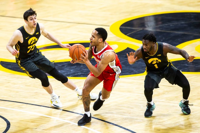 Ohio State guard CJ Walker, middle, passes as Iowa forward Patrick McCaffery, left, and Iowa guard Joe Toussaint (1) defend during a NCAA Big Ten Conference men's basketball game, Thursday, Feb. 4, 2021, at Carver-Hawkeye Arena in Iowa City, Iowa.