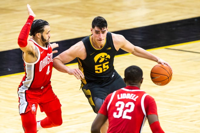 Iowa center Luka Garza (55) drives to the basket as Ohio State guard Duane Washington Jr. (4) defends during a NCAA Big Ten Conference men's basketball game, Thursday, Feb. 4, 2021, at Carver-Hawkeye Arena in Iowa City, Iowa.