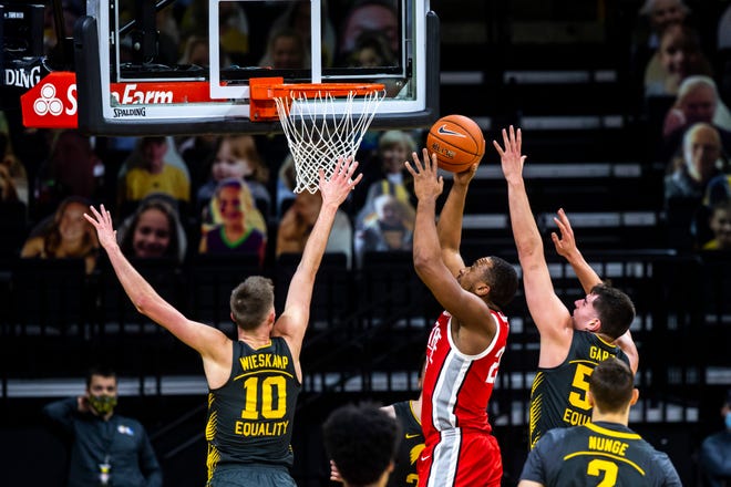 Ohio State forward Zed Key (23) makes a basket as Iowa's Joe Wieskamp (10) and Iowa center Luka Garza, right, defend during a NCAA Big Ten Conference men's basketball game, Thursday, Feb. 4, 2021, at Carver-Hawkeye Arena in Iowa City, Iowa.