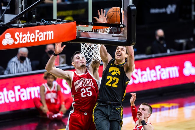 Iowa forward Patrick McCaffery (22) dunks the ball as Ohio State forwards Kyle Young (25) and Justin Ahrens, right, defend during a NCAA Big Ten Conference men's basketball game, Thursday, Feb. 4, 2021, at Carver-Hawkeye Arena in Iowa City, Iowa.