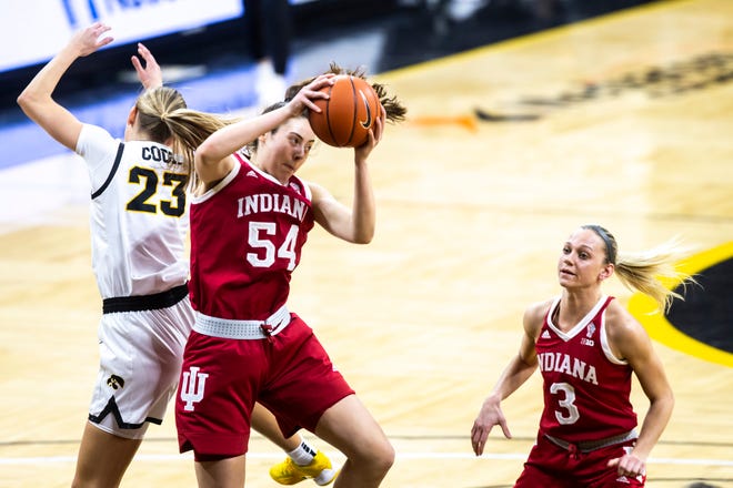 Indiana forward Mackenzie Holmes (54) pulls down a rebound against Iowa forward Logan Cook (23) as teammate Grace Waggoner (3) looks on during a NCAA Big Ten Conference women's basketball game, Sunday, Feb. 7, 2021, at Carver-Hawkeye Arena in Iowa City, Iowa.