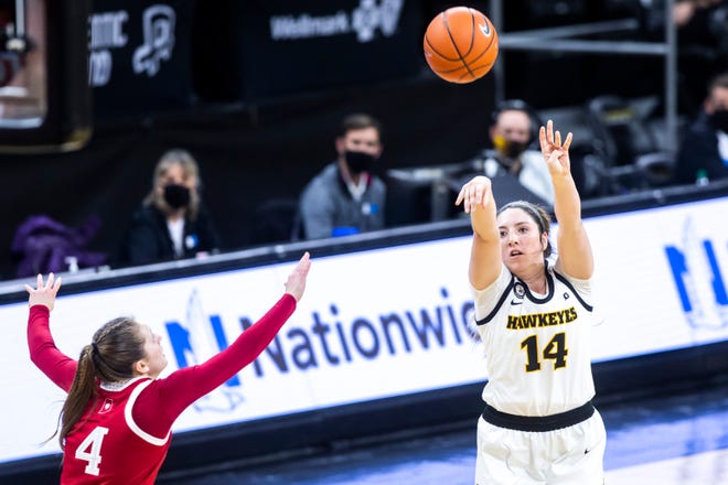 Iowa's McKenna Warnock (14) makes a 3-point basket as Indiana guard Nicole Cardaño-Hillary (4) defends during a NCAA Big Ten Conference women's basketball game, Sunday, Feb. 7, 2021, at Carver-Hawkeye Arena in Iowa City, Iowa.
