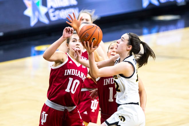 Iowa guard Caitlin Clark, right, drives to the basket as Indiana forward Aleksa Gulbe (10) and Indiana guard Ali Patberg (14) defend during a NCAA Big Ten Conference women's basketball game, Sunday, Feb. 7, 2021, at Carver-Hawkeye Arena in Iowa City, Iowa.