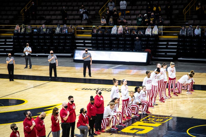 Members of the Indiana Hoosiers kneel as the national anthem is played before a NCAA Big Ten Conference women's basketball game against Iowa, Sunday, Feb. 7, 2021, at Carver-Hawkeye Arena in Iowa City, Iowa.