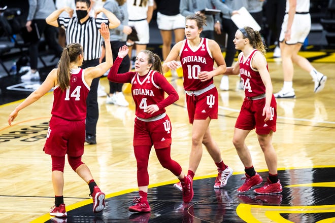 Indiana's Nicole Cardaño-Hillary (4) gets a high-five from Ali Patberg (14) while heading into a timeout with teammates Aleksa Gulbe (10) and Grace Berger (34) during a NCAA Big Ten Conference women's basketball game, Sunday, Feb. 7, 2021, at Carver-Hawkeye Arena in Iowa City, Iowa.