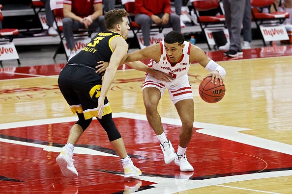 MADISON, WISCONSIN - FEBRUARY 18: D'Mitrik Trice #0 of the Wisconsin Badgers dribbles the ball while being guarded by Jordan Bohannon #3 of the Iowa Hawkeyes in the first half at the Kohl Center on February 18, 2021 in Madison, Wisconsin. (Photo by Dylan Buell/Getty Images)