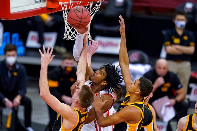 Wisconsin's Aleem Ford, center, goes up against Iowa's Joe Wieskamp, left, and Keegan Murray during the first half of an NCAA college basketball game Thursday, Feb. 18, 2021, in Madison, Wis. (AP Photo/Andy Manis)
