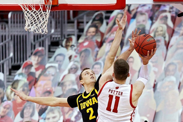 MADISON, WISCONSIN - FEBRUARY 18: Micah Potter #11 of the Wisconsin Badgers attempts a shot while being guarded by Jack Nunge #2 of the Iowa Hawkeyes in the second half at the Kohl Center on February 18, 2021 in Madison, Wisconsin. (Photo by Dylan Buell/Getty Images)