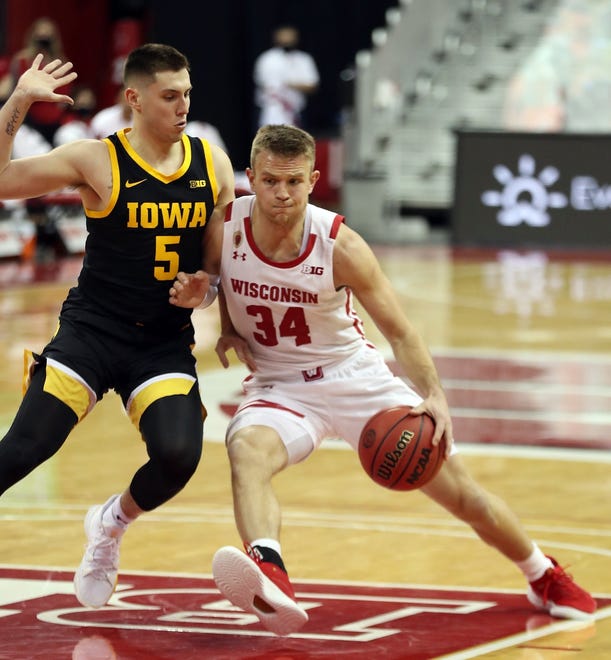 Feb 18, 2021; Madison, Wisconsin, USA; Wisconsin Badgers guard Brad Davison (34) works the ball against Iowa Hawkeyes guard C.J. Fredrick (5) during the first half at the Kohl Center. Mandatory Credit: Mary Langenfeld-USA TODAY Sports