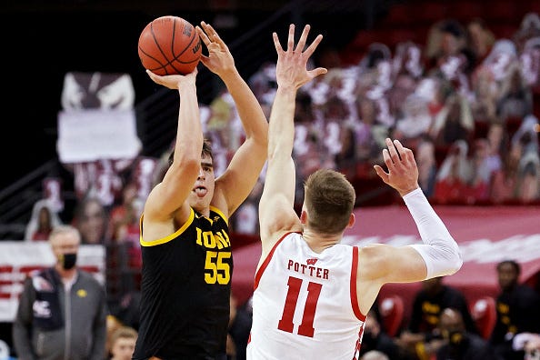 MADISON, WISCONSIN - FEBRUARY 18: Luka Garza #55 of the Iowa Hawkeyes attempts a shot while being guarded by Micah Potter #11 of the Wisconsin Badgers in the first half at the Kohl Center on February 18, 2021 in Madison, Wisconsin. (Photo by Dylan Buell/Getty Images)