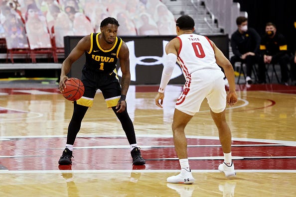 MADISON, WISCONSIN - FEBRUARY 18: Joe Toussaint #1 of the Iowa Hawkeyes dribbles the ball while being guarded by D'Mitrik Trice #0 of the Wisconsin Badgers in the first half at the Kohl Center on February 18, 2021 in Madison, Wisconsin. (Photo by Dylan Buell/Getty Images)