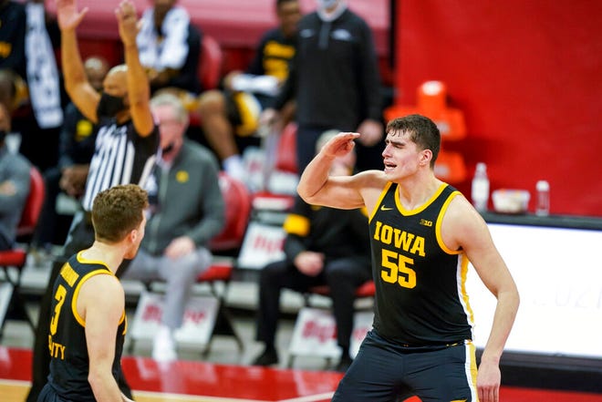 Iowa's Luka Garza (55) salutes his teammates on a basket against Wisconsin during the second half of an NCAA college basketball game Thursday, Feb. 18, 2021, in Madison, Wis. Iowa won 77-62 (AP Photo/Andy Manis)