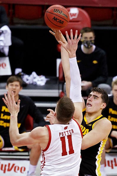 MADISON, WISCONSIN - FEBRUARY 18: Luka Garza #55 of the Iowa Hawkeyes attempts a shot while being guarded by Micah Potter #11 of the Wisconsin Badgers in the second half at the Kohl Center on February 18, 2021 in Madison, Wisconsin. (Photo by Dylan Buell/Getty Images)