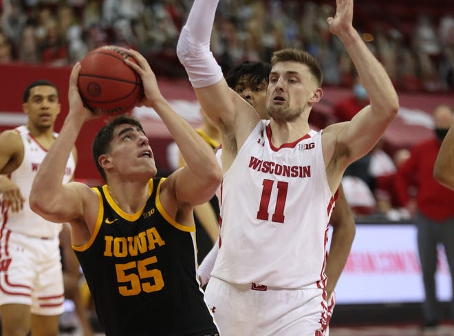 Feb 18, 2021; Madison, Wisconsin, USA; Iowa Hawkeyes center Luka Garza (55) looks to shoot as Wisconsin Badgers forward Micah Potter (11) defends  during the second half at the Kohl Center. Mandatory Credit: Mary Langenfeld-USA TODAY Sports