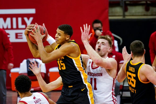 Iowa's Keegan Murray (15) gets a defensive rebound away from Wisconsin's Micah Potter (11) during the second half of an NCAA college basketball game Thursday, Feb. 18, 2021, in Madison, Wis. (AP Photo/Andy Manis)
