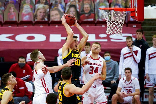 Iowa's Joe Wieskamp (10) rebounds against Wisconsin's Micah Potter, left, and Brad Davison (34) during the second half of an NCAA college basketball game Thursday, Feb. 18, 2021, in Madison, Wis. (AP Photo/Andy Manis)