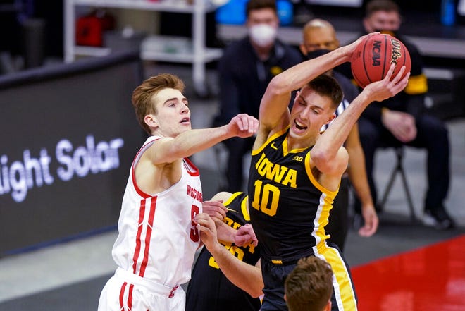 Iowa's Joe Wieskamp (10) pulls down a defensive rebound against Wisconsin's Tyler Wahl (5) during the first half of an NCAA college basketball game Thursday, Feb. 18, 2021, in Madison, Wis. (AP Photo/Andy Manis)