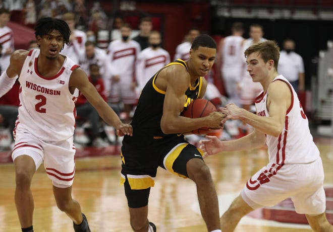 Feb 18, 2021; Madison, Wisconsin, USA; Wisconsin Badgers forward Tyler Wahl (5) attempts to take the ball from Iowa Hawkeyes forward Keegan Murray (15) during the second half at the Kohl Center. Mandatory Credit: Mary Langenfeld-USA TODAY Sports