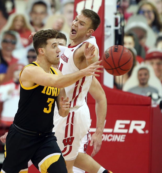Feb 18, 2021; Madison, Wisconsin, USA; Iowa Hawkeyes guard Jordan Bohannon (3) passes the ball as Wisconsin Badgers guard Brad Davison (right) defends during the first half at the Kohl Center. Mandatory Credit: Mary Langenfeld-USA TODAY Sports