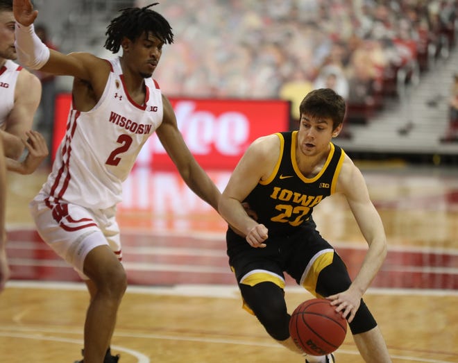 Feb 18, 2021; Madison, Wisconsin, USA; Iowa Hawkeyes forward Patrick McCaffery (22) dribbles the ball past Wisconsin Badgers forward Aleem Ford (2) during the second half at the Kohl Center. Mandatory Credit: Mary Langenfeld-USA TODAY Sports