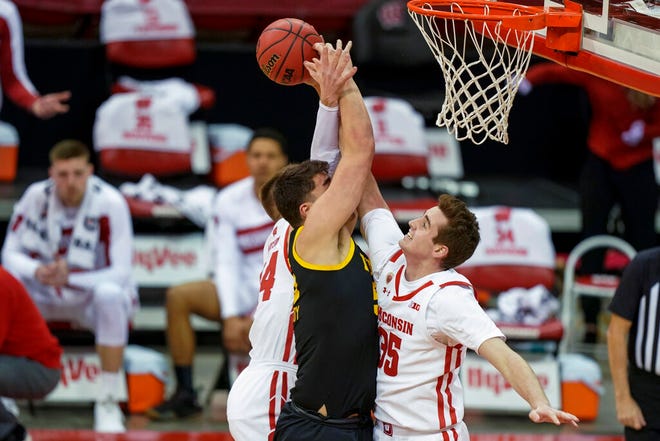 Wisconsin's Nate Reuvers (35) defends against Iowa's Luka Garza (55) during the first half of an NCAA college basketball game Thursday, Feb. 18, 2021, in Madison, Wis. (AP Photo/Andy Manis)