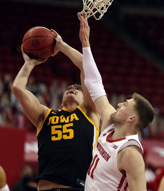 Feb 18, 2021; Madison, Wisconsin, USA; Wisconsin Badgers forward Micah Potter (11) attempts to block a shot from Iowa Hawkeyes center Luka Garza (55) during the second half at the Kohl Center. Mandatory Credit: Mary Langenfeld-USA TODAY Sports