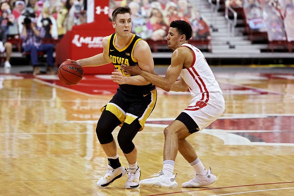 MADISON, WISCONSIN - FEBRUARY 18: Connor McCaffery #30 of the Iowa Hawkeyes dribbles the ball while being guarded by D'Mitrik Trice #0 of the Wisconsin Badgers in the first half at the Kohl Center on February 18, 2021 in Madison, Wisconsin. (Photo by Dylan Buell/Getty Images)