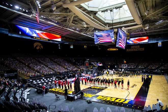A general view as Wisconsin Badgers and Iowa Hawkeyes players stand for the national anthem during a NCAA Big Ten Conference men's basketball game, Sunday, March 7, 2021, at Carver-Hawkeye Arena in Iowa City, Iowa.