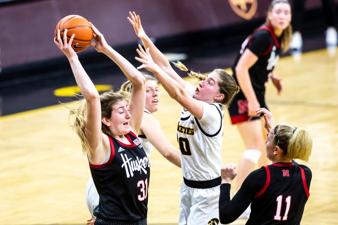 Nebraska center Kate Cain, left, grabs a rebound against Iowa guard Kate Martin as Nebraska guard Ruby Porter (11) looks on during a NCAA Big Ten Conference women's basketball game, Saturday, March 6, 2021, at Carver-Hawkeye Arena in Iowa City, Iowa.