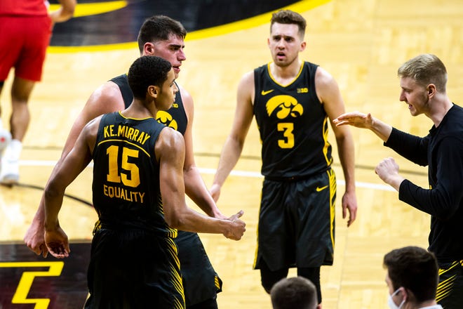 Iowa forward Keegan Murray (15) is embraced by teammates Luka Garza, second from left, Jordan Bohannon (3) and Michael Baer, right, after pulling down a rebound on a missed free throw during a NCAA Big Ten Conference men's basketball game against Wisconsin, Sunday, March 7, 2021, at Carver-Hawkeye Arena in Iowa City, Iowa.