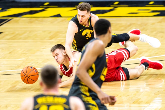 Wisconsin guard Brad Davison, left, and Iowa guard Jordan Bohannon battle for a loose ball during a NCAA Big Ten Conference men's basketball game, Sunday, March 7, 2021, at Carver-Hawkeye Arena in Iowa City, Iowa.