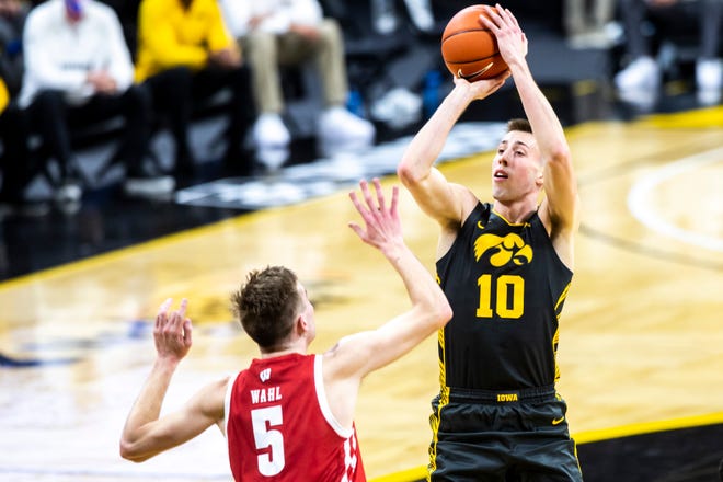 Iowa's Joe Wieskamp (10) makes a basket as Wisconsin forward Tyler Wahl (5) defends during a NCAA Big Ten Conference men's basketball game, Sunday, March 7, 2021, at Carver-Hawkeye Arena in Iowa City, Iowa.