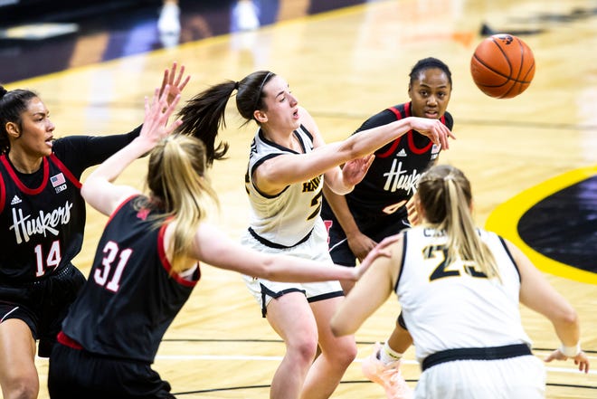 Iowa guard Caitlin Clark passes while being covering by Nebraska's Bella Cravens (14) Kate Cain (31) and Sam Haiby during a NCAA Big Ten Conference women's basketball game, Saturday, March 6, 2021, at Carver-Hawkeye Arena in Iowa City, Iowa.