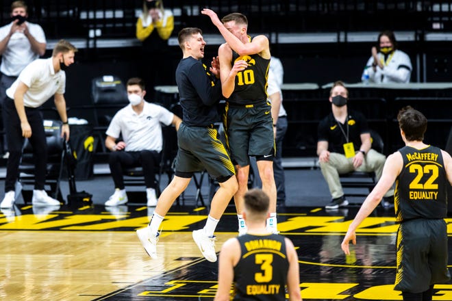 Iowa's Joe Wieskamp (10) celebrates with teammate Austin Ash after making a 3-point basket during a NCAA Big Ten Conference men's basketball game against Wisconsin, Sunday, March 7, 2021, at Carver-Hawkeye Arena in Iowa City, Iowa.