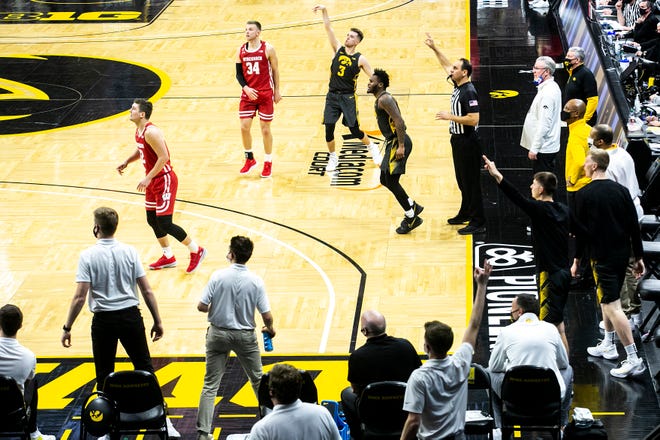Iowa guard Jordan Bohannon (3) watches as he makes a 3-point basket while Wisconsin guard Brad Davison (34) defends during a NCAA Big Ten Conference men's basketball game, Sunday, March 7, 2021, at Carver-Hawkeye Arena in Iowa City, Iowa.