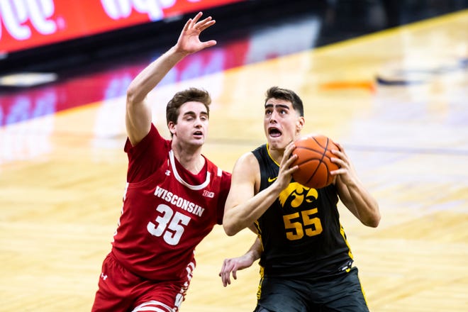 Iowa center Luka Garza (55) makes a basket as Wisconsin forward Nate Reuvers (35) defends during a NCAA Big Ten Conference men's basketball game, Sunday, March 7, 2021, at Carver-Hawkeye Arena in Iowa City, Iowa.