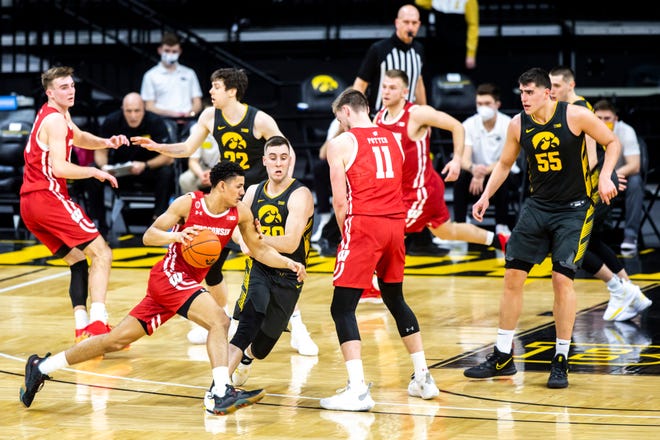 Wisconsin guard Jonathan Davis drives against Iowa's Connor McCaffery (30) during a NCAA Big Ten Conference men's basketball game, Sunday, March 7, 2021, at Carver-Hawkeye Arena in Iowa City, Iowa.