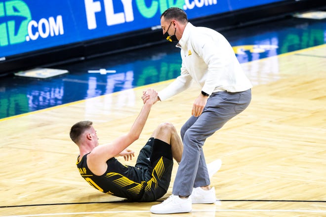 Iowa's Joe Wieskamp (10) gets helped up by athletic trainer Brad Floy during a NCAA Big Ten Conference men's basketball game against Wisconsin, Sunday, March 7, 2021, at Carver-Hawkeye Arena in Iowa City, Iowa.