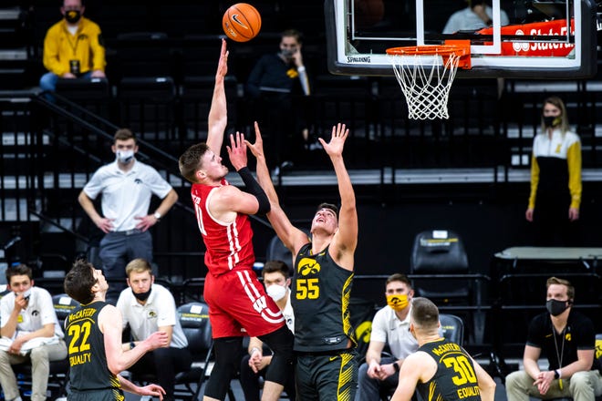 Wisconsin forward Micah Potter (11) makes a basket as Iowa center Luka Garza (55) defends during a NCAA Big Ten Conference men's basketball game, Sunday, March 7, 2021, at Carver-Hawkeye Arena in Iowa City, Iowa.