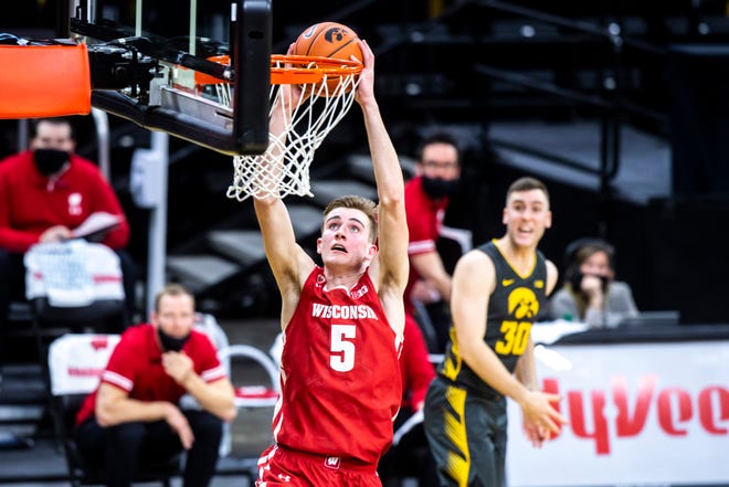 Wisconsin forward Tyler Wahl (5) dunks the ball as Iowa's Connor McCaffery (30) reacts during a NCAA Big Ten Conference men's basketball game, Sunday, March 7, 2021, at Carver-Hawkeye Arena in Iowa City, Iowa.