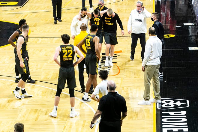 Iowa's Joe Wieskamp (10) is helped off the floor by athletic trainer Brad Floy and teammate Michael Baer during a NCAA Big Ten Conference men's basketball game against Wisconsin, Sunday, March 7, 2021, at Carver-Hawkeye Arena in Iowa City, Iowa.