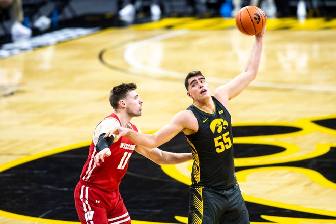 Iowa center Luka Garza (55) catches a pass as Wisconsin forward Micah Potter (11) defends during a NCAA Big Ten Conference men's basketball game, Sunday, March 7, 2021, at Carver-Hawkeye Arena in Iowa City, Iowa.