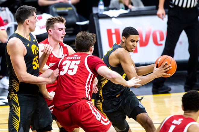 Iowa forward Keegan Murray (15) drives to the basket as Wisconsin forwards Tyler Wahl and Nate Reuvers (35) defend as Iowa center Luka Garza (55) looks on during a NCAA Big Ten Conference men's basketball game, Sunday, March 7, 2021, at Carver-Hawkeye Arena in Iowa City, Iowa.