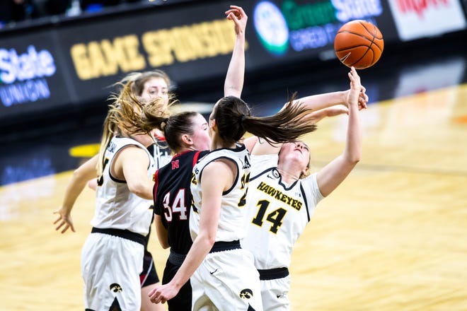 Iowa's McKenna Warnock (14) pulls down a rebound against Nebraska forward Isabelle Bourne (34) during a NCAA Big Ten Conference women's basketball game, Saturday, March 6, 2021, at Carver-Hawkeye Arena in Iowa City, Iowa.