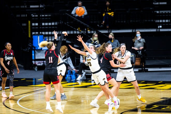Nebraska guard Ruby Porter (11) makes a 3-point basket as Iowa guard Kate Martin (20) defends during a NCAA Big Ten Conference women's basketball game, Saturday, March 6, 2021, at Carver-Hawkeye Arena in Iowa City, Iowa.