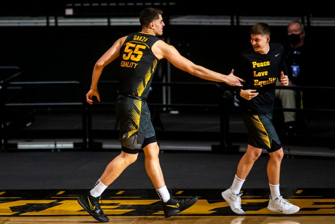 Iowa center Luka Garza (55) grabs teammate Austin Ash during introductions before a NCAA Big Ten Conference men's basketball game against Wisconsin, Sunday, March 7, 2021, at Carver-Hawkeye Arena in Iowa City, Iowa.