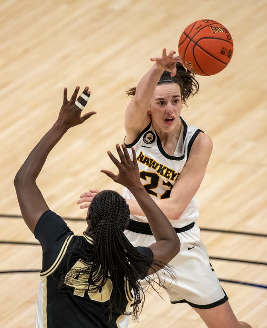Iowa Hawkeyes guard Caitlin Clark (22) passes to a teammate as Purdue Boilermakers center Fatou Diagne (45) defends on Wednesday, March 10, 2021, during the women's Big Ten basketball tournament from Bankers Life Fieldhouse in Indianapolis.